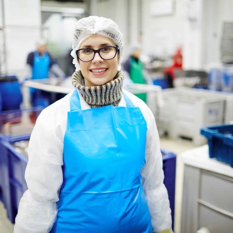 Auf diesem Bild ist eine Saosonarbeiter:in zu sehen, welche sich in einer Produktion / Verpackung befindet.